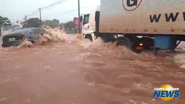 Carro enguiçado em alagamento é levado pela força da água