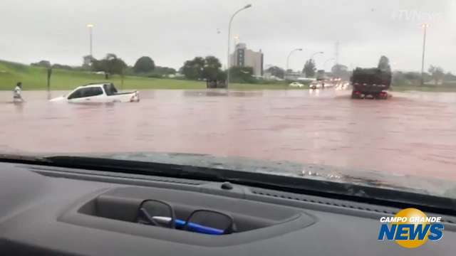 Motoristas arriscam a sorte em trecho alagado da Avenida João Arinos