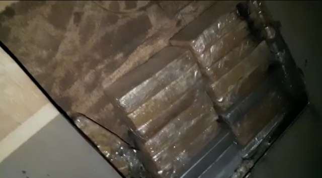 Bombeiro serrando fundo falso de carreta onde estava 100 quilos de cocaína