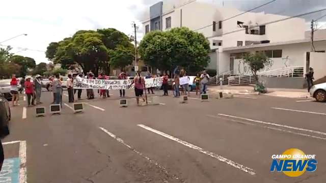 Com computadores e em trajes de guerra, índios fecham rua