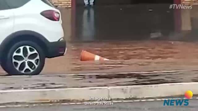 Em trecho alagado de avenida, cone de sinalização é arrastado