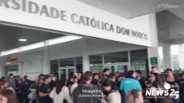 Candidatos se abrigam da chuva na UCDB