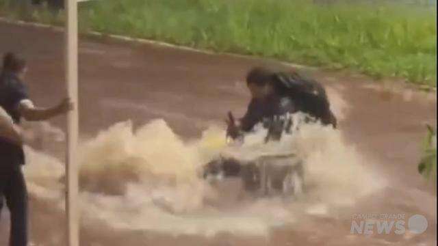Homem tenta recuperar moto levada por enxurrada
