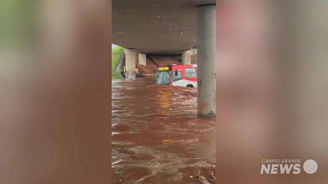 Ônibus e carreta atravessam alagamento da João Arinos